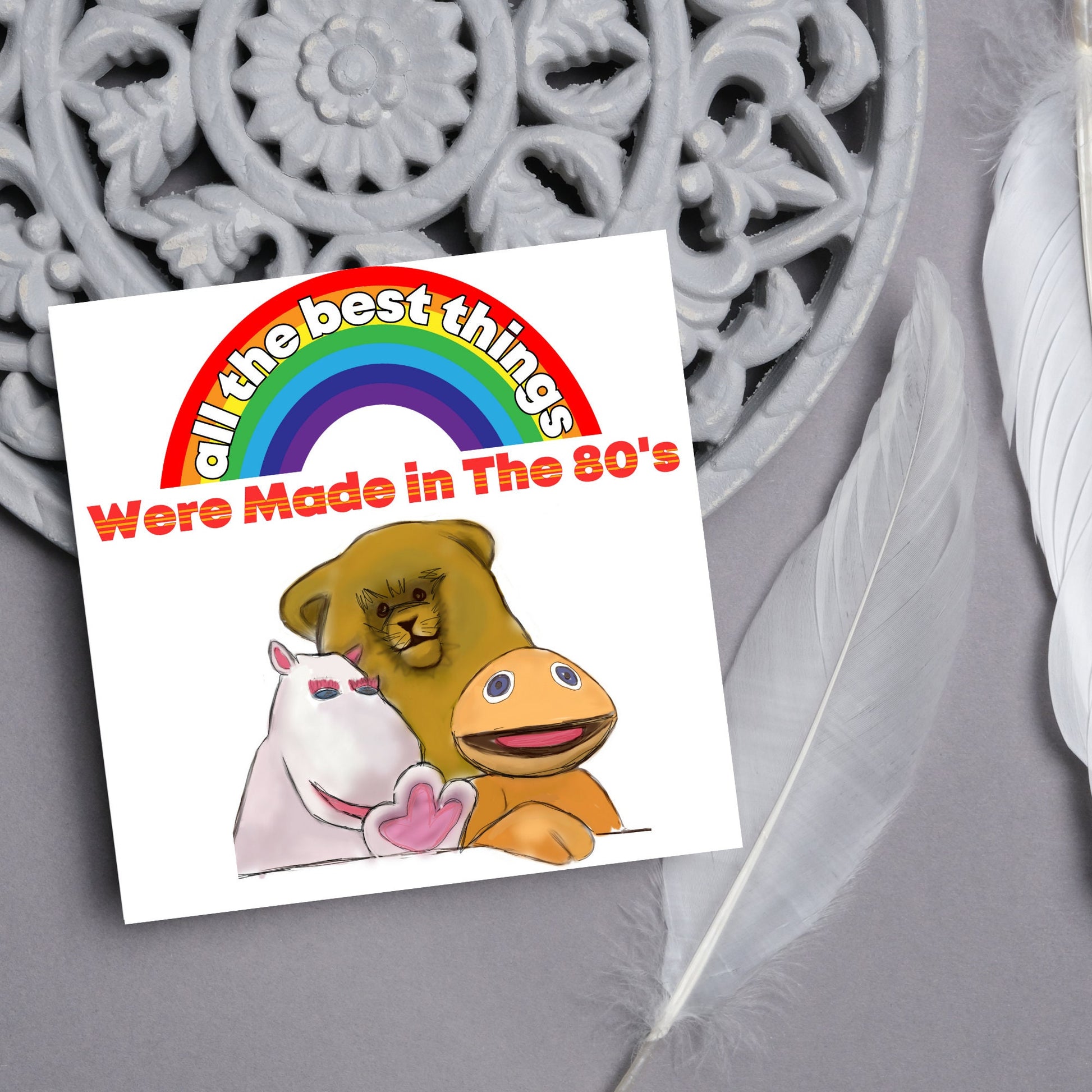 square card featuring an illustration of the characters from the tv show rainbow with a rainbow and red text that reads  &#39;all the best things were&#39; made in the 80&#39;s&#39; in the font from the shows title