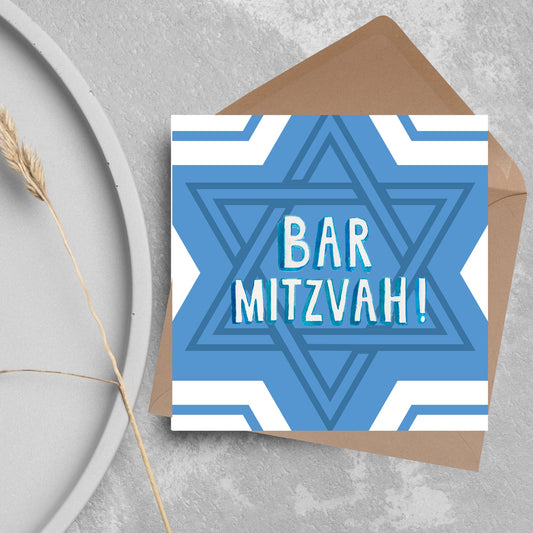 white and blue bar mitzvah card, geometric design with a repeating star of david at the centre in various shades of blue. At the centre of the card in white writing are the words &#39;bar mitzvah!&#39; in capital letters in a handwritten style font