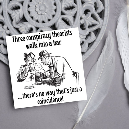 Image of a square greetings card with a hand drawn black and white line cartoon sketch of two old men at a bar drinking beer with the text- 3 conspiracy theorists walk into a bar....there&#39;s no way that&#39;s just a coincidence!