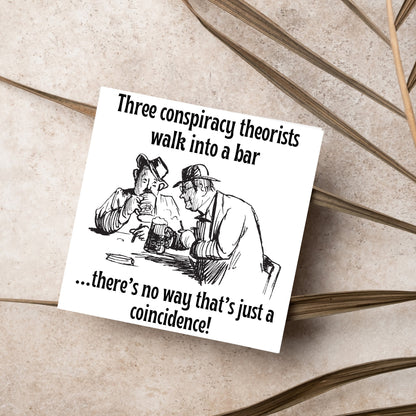 Image of a square greetings card with a hand drawn black and white line cartoon sketch of two old men at a bar drinking beer with the text- 3 conspiracy theorists walk into a bar....there&#39;s no way that&#39;s just a coincidence!