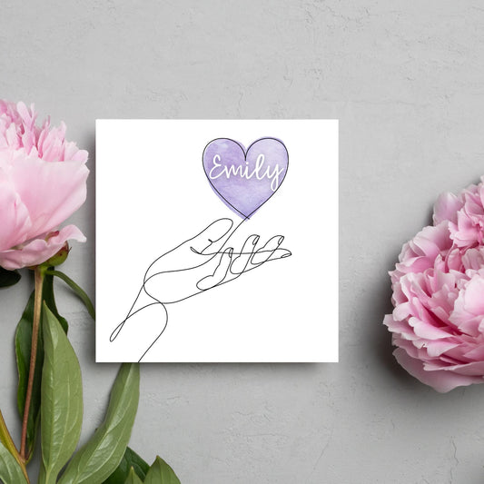 square card with a simple black and white one line drawing of an open hand with a heart rising from the hand. the heart has a purple background and has a personalised name written in a white cursive text