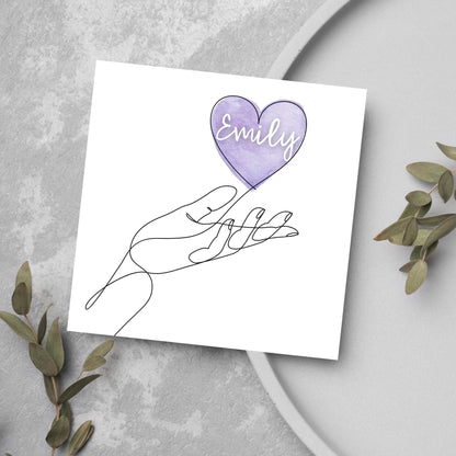 square card with a simple black and white one line drawing of an open hand with a heart rising from the hand. the heart has a purple background and has a personalised name written in a white cursive text