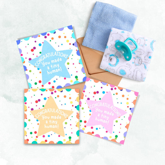 Image of 3 square cards, one pink, one yellow and one blue, the card design is a multicoloured polka dot design with a large coloured star in the middle and white text against the star that reads CONGRATULATIONS You made a tiny human!
