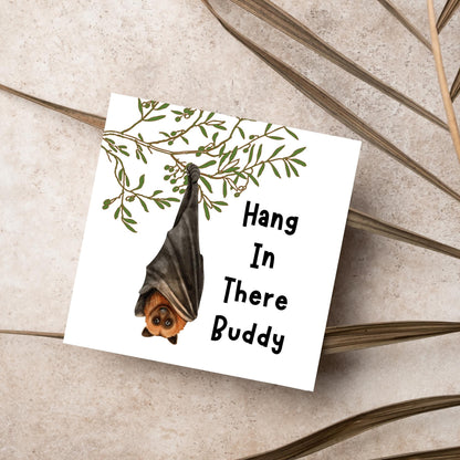 square card with an illustration of a bat hanging upside down from a tree branch with black text next to it that reads - Hang in there buddy