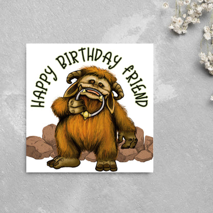 This square shaped card has an illustration of Ludo from the 80s Bowie film Labyrinth. Ludo towers over some rocks and has a door knocker in their mouth. The caption reads Happy Birthday Friend, this text arches above Ludo. This card is perfect for any fans of the film Labyrinth