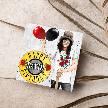 Square Birthday card with an illustration of Slash from Guns and Roses holding a red balloon and a black balloon in one hand, and resting his other on his guitar. He is wearing his trademark top hat, a rose print tee shirt and sunglasses. There is a band style logo that reads happy birthday david to the left of him.