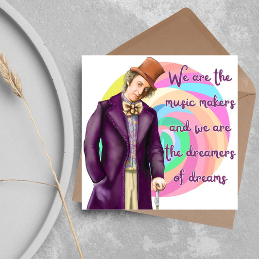 Image of a square greeting card. The background of the card is white and there is a hand drawn image of Gene Wilder as Willy Wonka wearing his purple coat, top hat and bow tie. Behind him is a colourful swirly lollypop and purple text reads &#39;we are the music makers and we are the dreamers of dreams&#39; in a curly font.