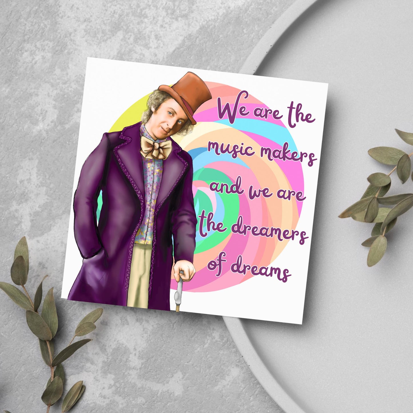 Image of a square greeting card. The background of the card is white and there is a hand drawn image of Gene Wilder as Willy Wonka wearing his purple coat, top hat and bow tie. Behind him is a colourful swirly lollypop and purple text reads &#39;we are the music makers and we are the dreamers of dreams&#39; in a curly font.