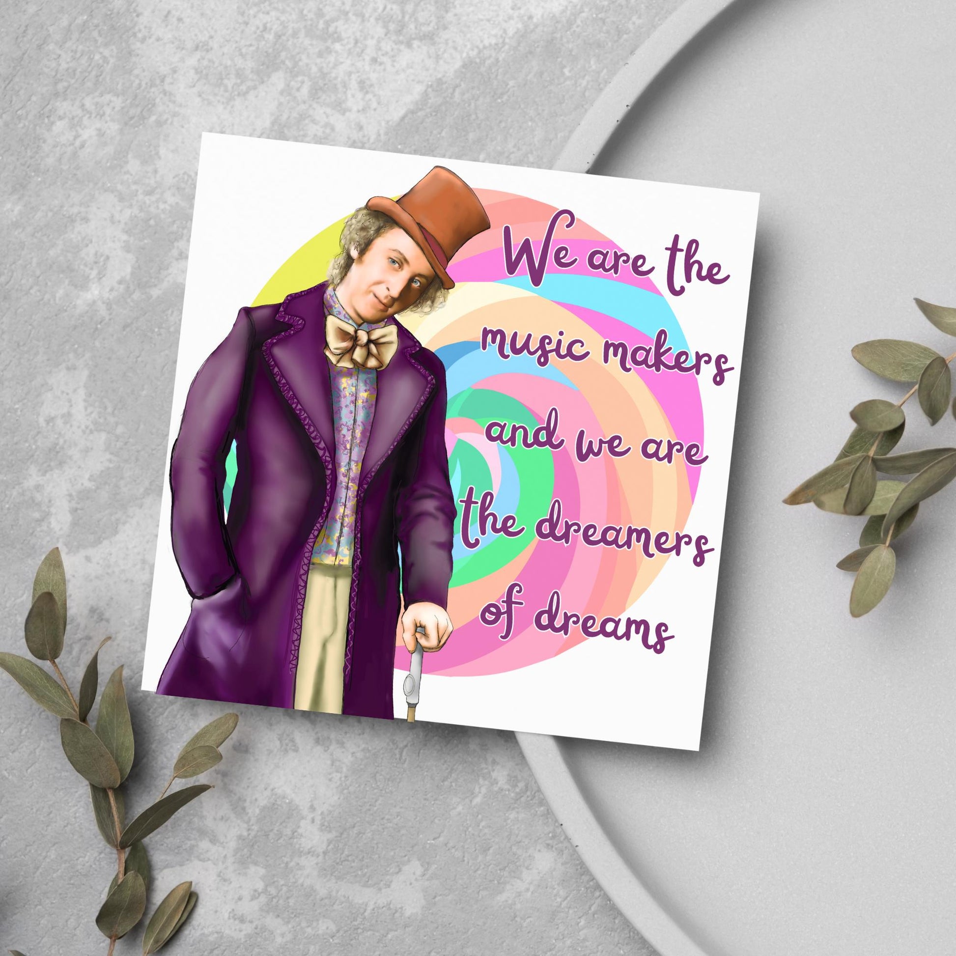 Image of a square greeting card. The background of the card is white and there is a hand drawn image of Gene Wilder as Willy Wonka wearing his purple coat, top hat and bow tie. Behind him is a colourful swirly lollypop and purple text reads &#39;we are the music makers and we are the dreamers of dreams&#39; in a curly font.