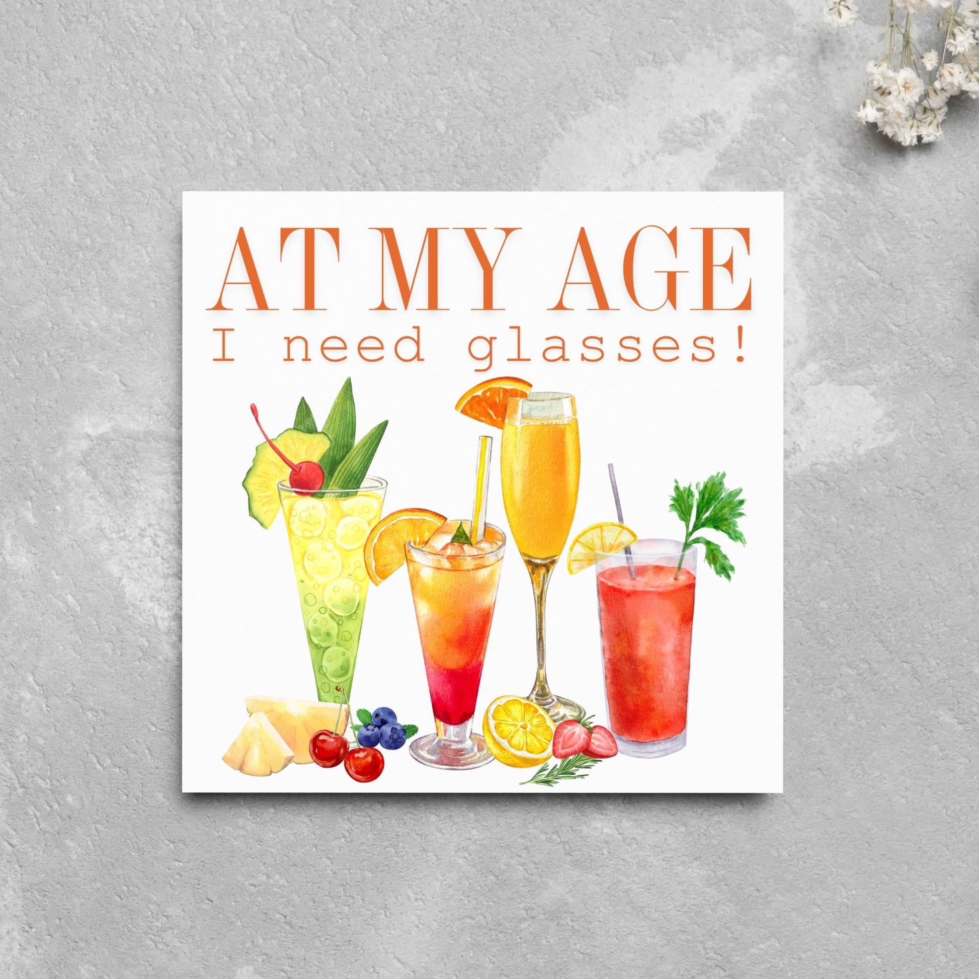Image of a square birthday card with colourful illustrations of cocktails with the text - at my age I need glasses!