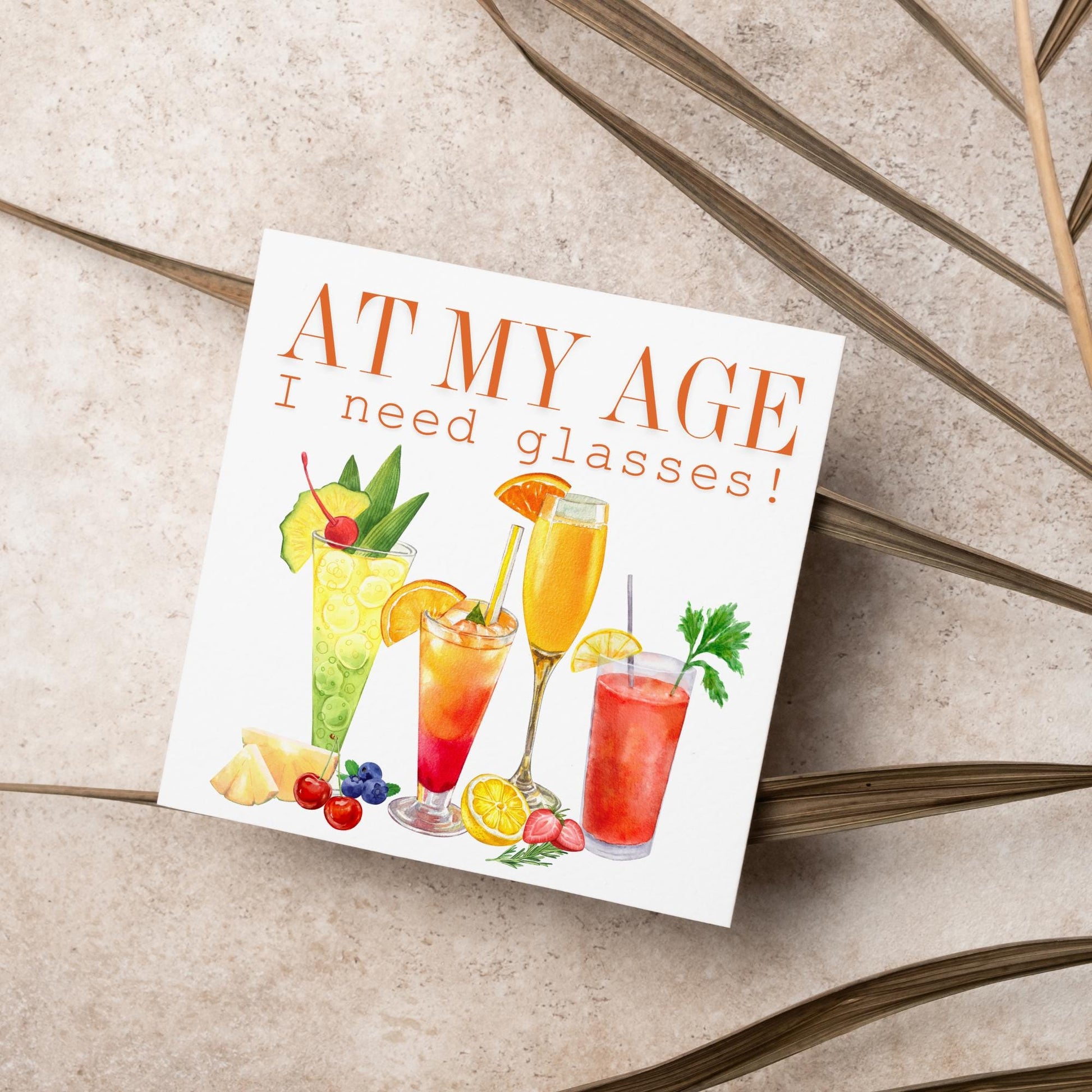 Image of a square birthday card with colourful illustrations of cocktails with the text - at my age I need glasses!